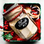 Gluten free cookie mix in a jar in a box with red tissue paper and cranberries