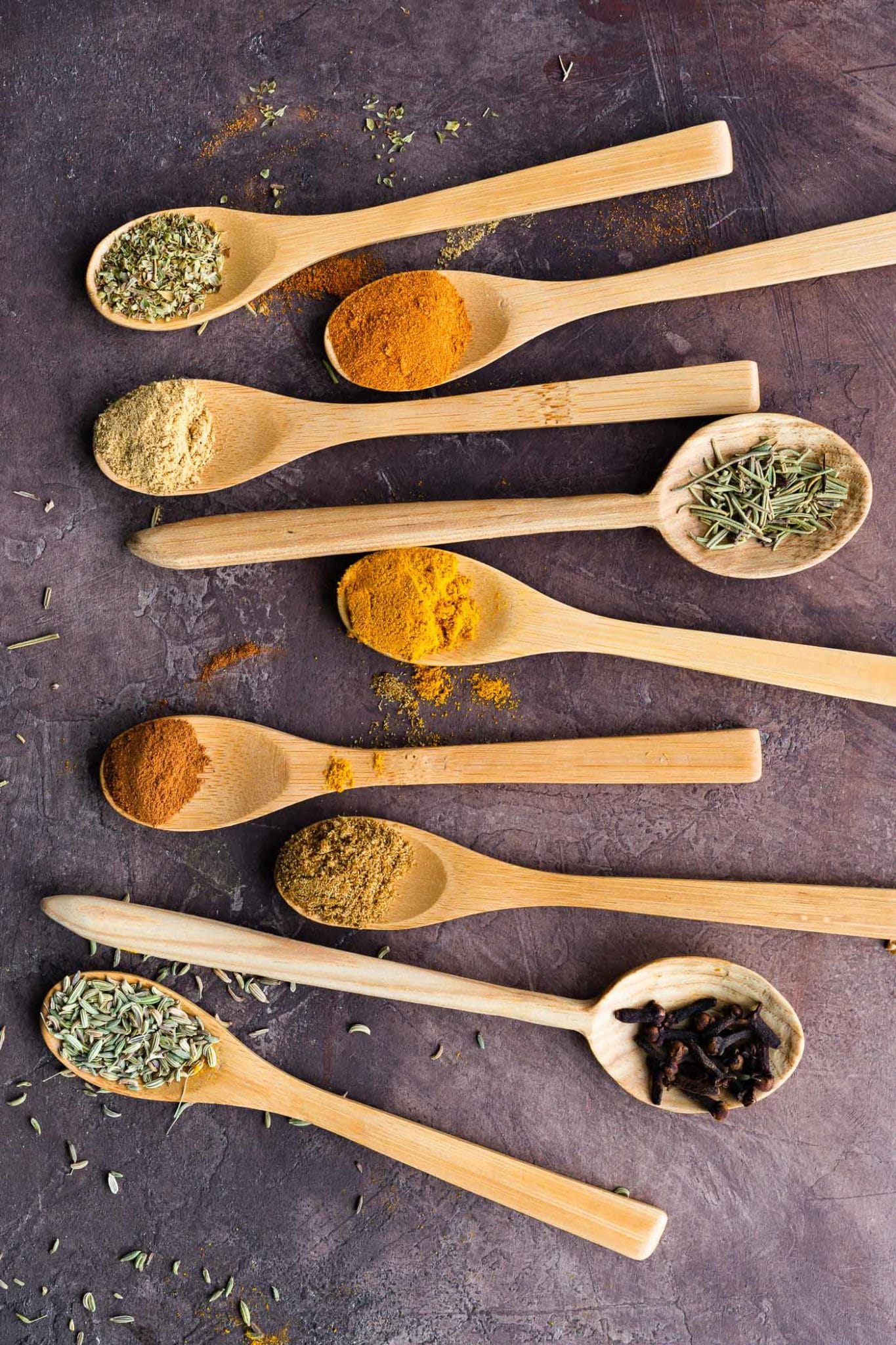 various herbs and spices on wooden spoons