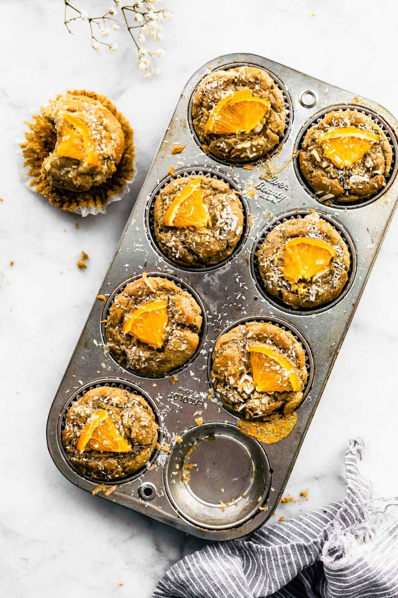 Overhead view eight-count muffin tin filled with coconut orange muffins.