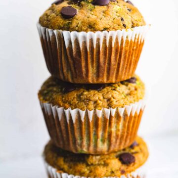 a stack of three chocolate chip gluten free zucchini muffins on top of each other
