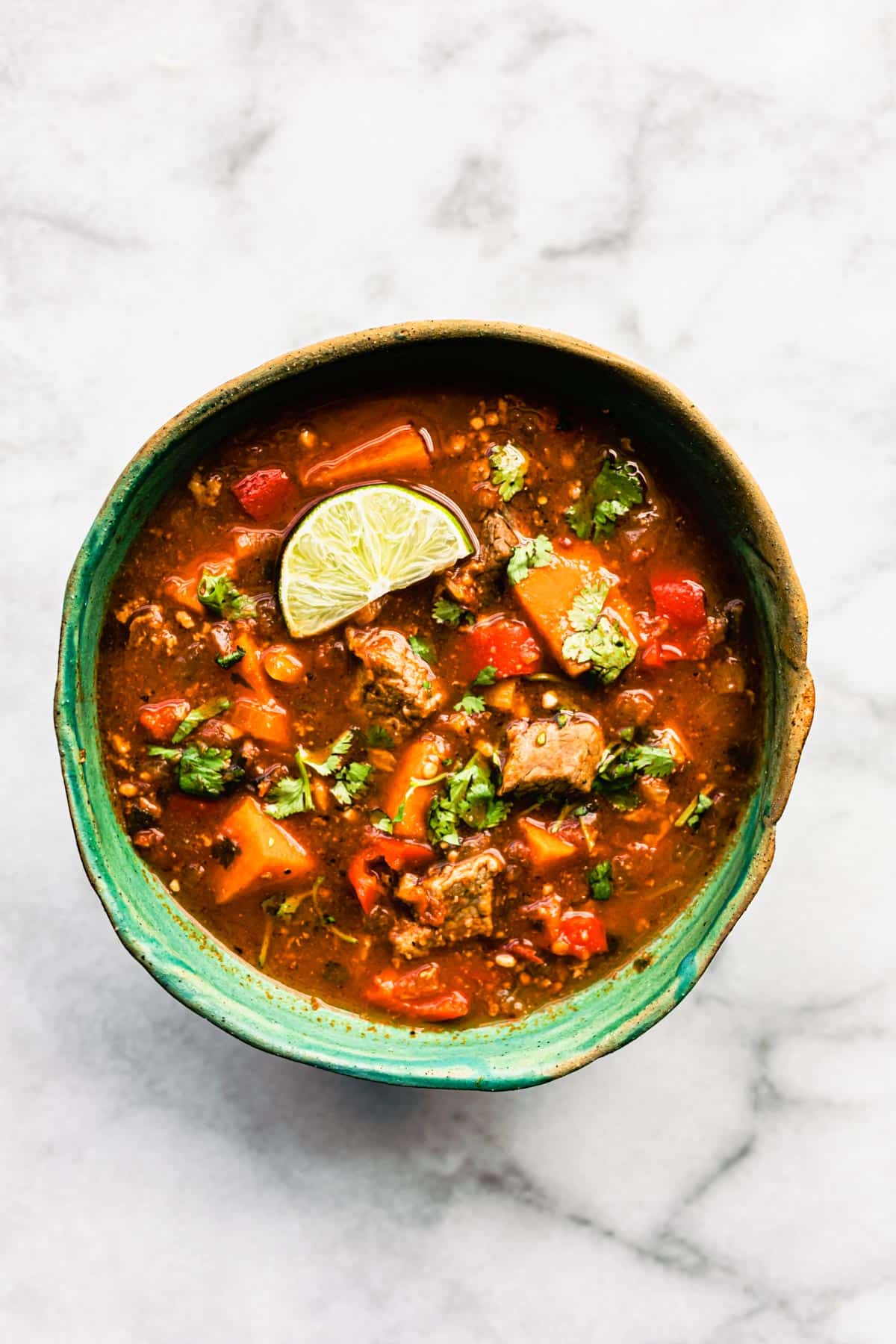 overhead bowl of mexican sweet potato beef stew slow cooker recipe topped with a lime wedge