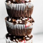 A stack of three gluten free Peppermint Chocolate Muffins on a white countertop.