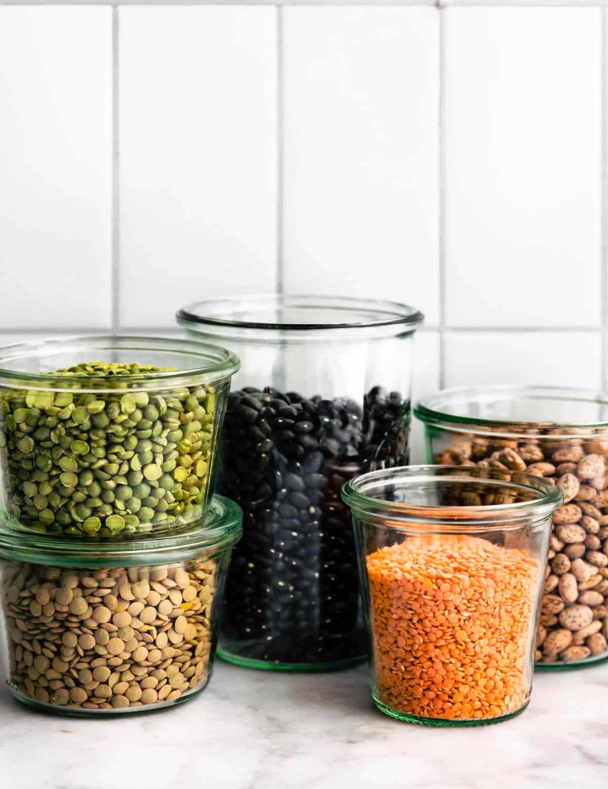 Assorted beans and legumes in glass jars. 