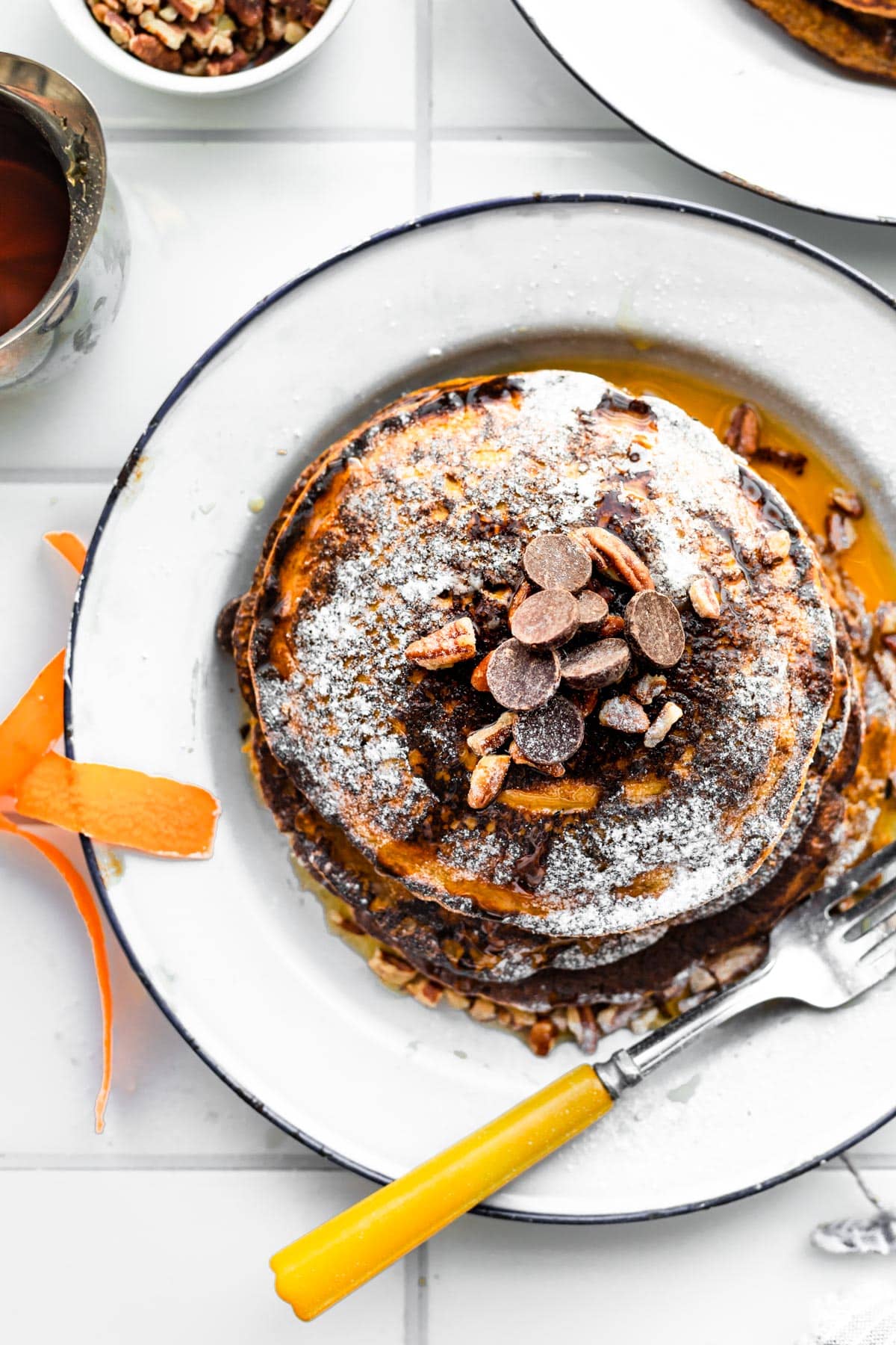 overhead image of a stack of gluten-free carrot cake pancakes on a plate with a fork