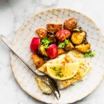 Easy Baked Fish and Vegetables on a plate with a fork cutting the fish.