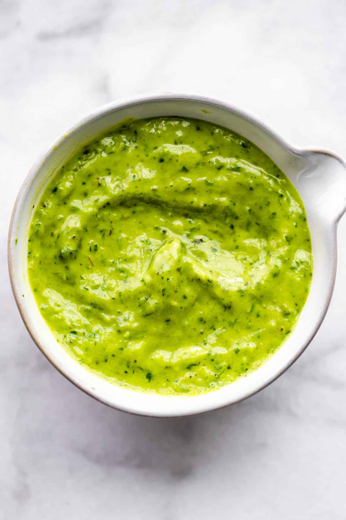 Vegan green goddess dressing in a white bowl.