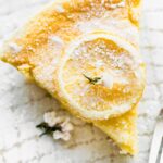 Overhead image of a slice of gluten free lemon pudding cake dusted with powdered sugar.