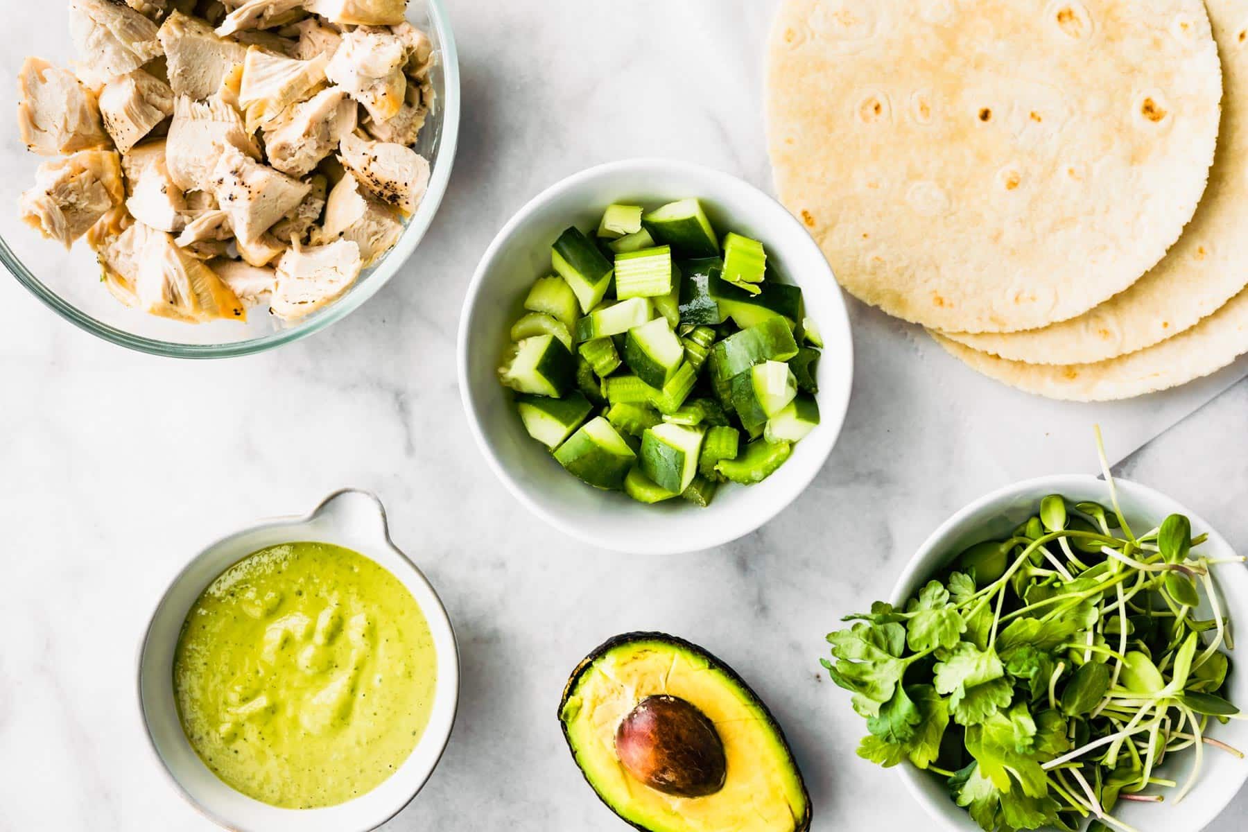 Bowls of ingredients for green goddess chicken salad wraps.
