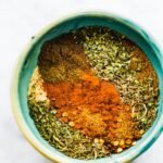 Overhead view of individual spices in a small bowl for jerk seasoning.