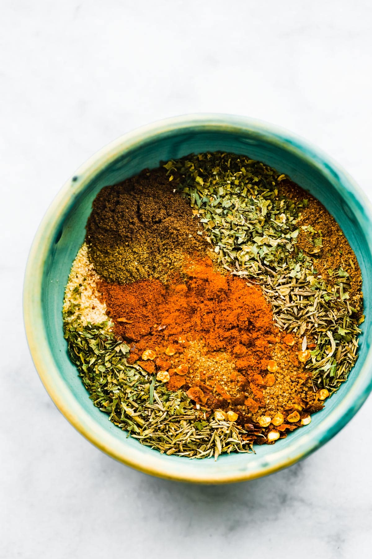 Overhead view of individual spices in a small bowl for jerk seasoning.