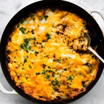 A cheesy spaghetti squash casserole with a spoon in it.