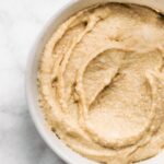 Up close overhead photo of maple cream cheese frosting in a white bowl.