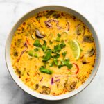 Overhead photo of Easy Thai Coconut Soup in a white bowl garnished with cilantro.