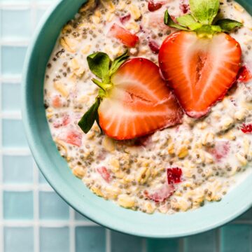 Overhead photo of strawberry overnight oats topped with two strawberry halves.