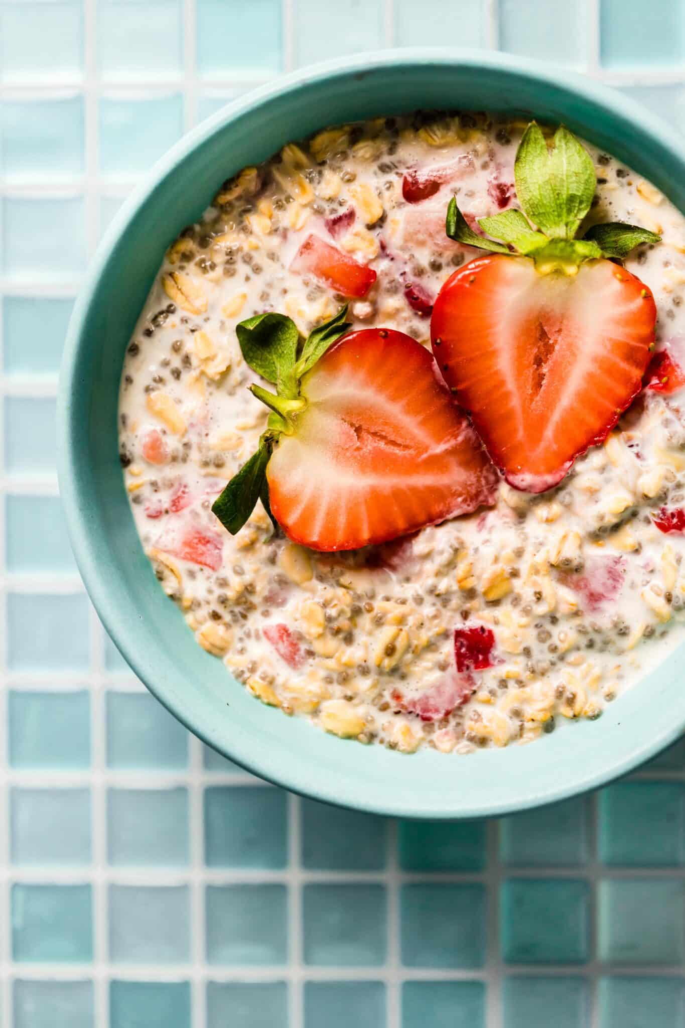 Overhead photo of strawberry overnight oats topped with two strawberry halves.