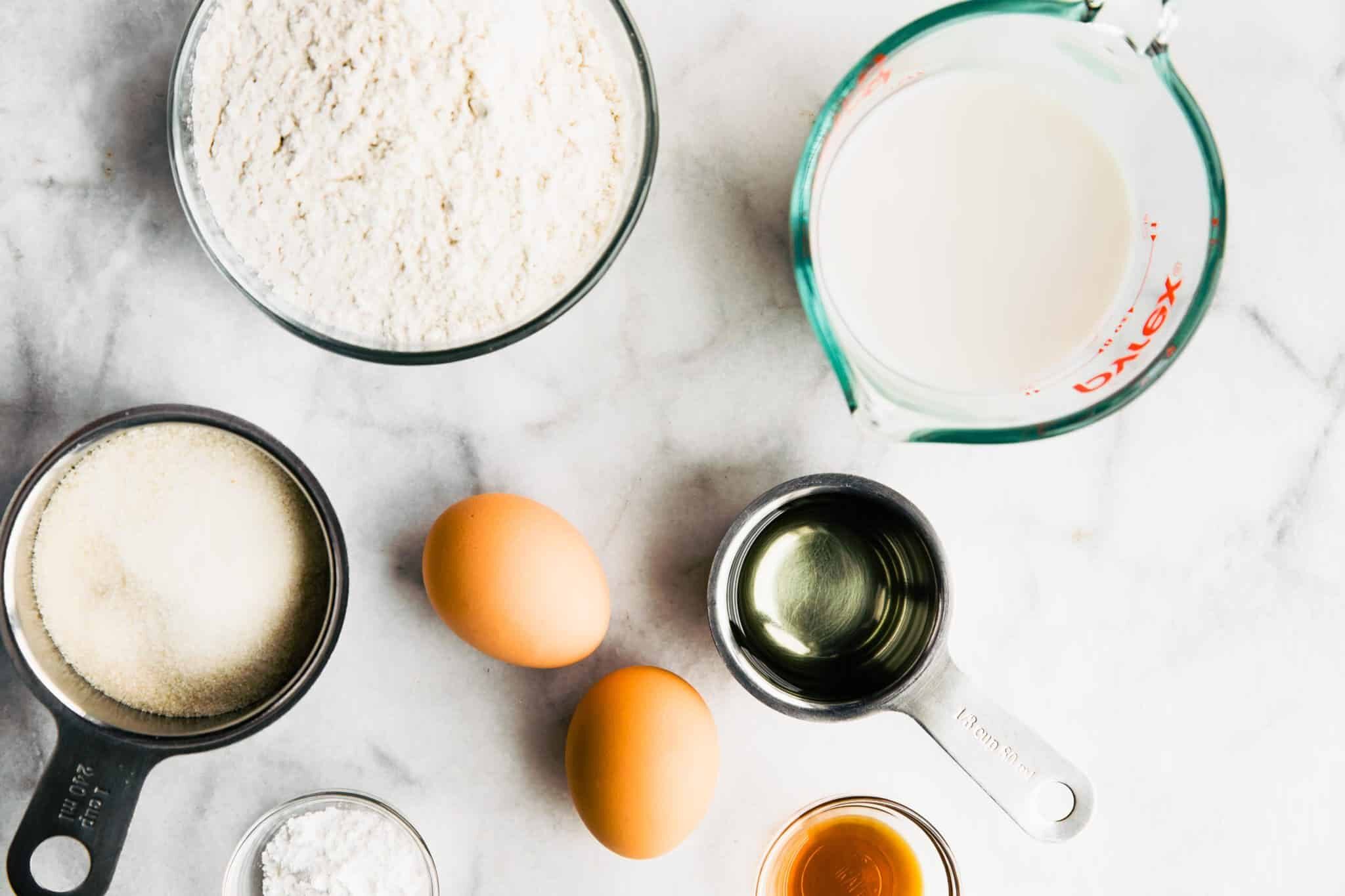 Overhead photo of ingredients for churro cupcakes on a white marble countertop.