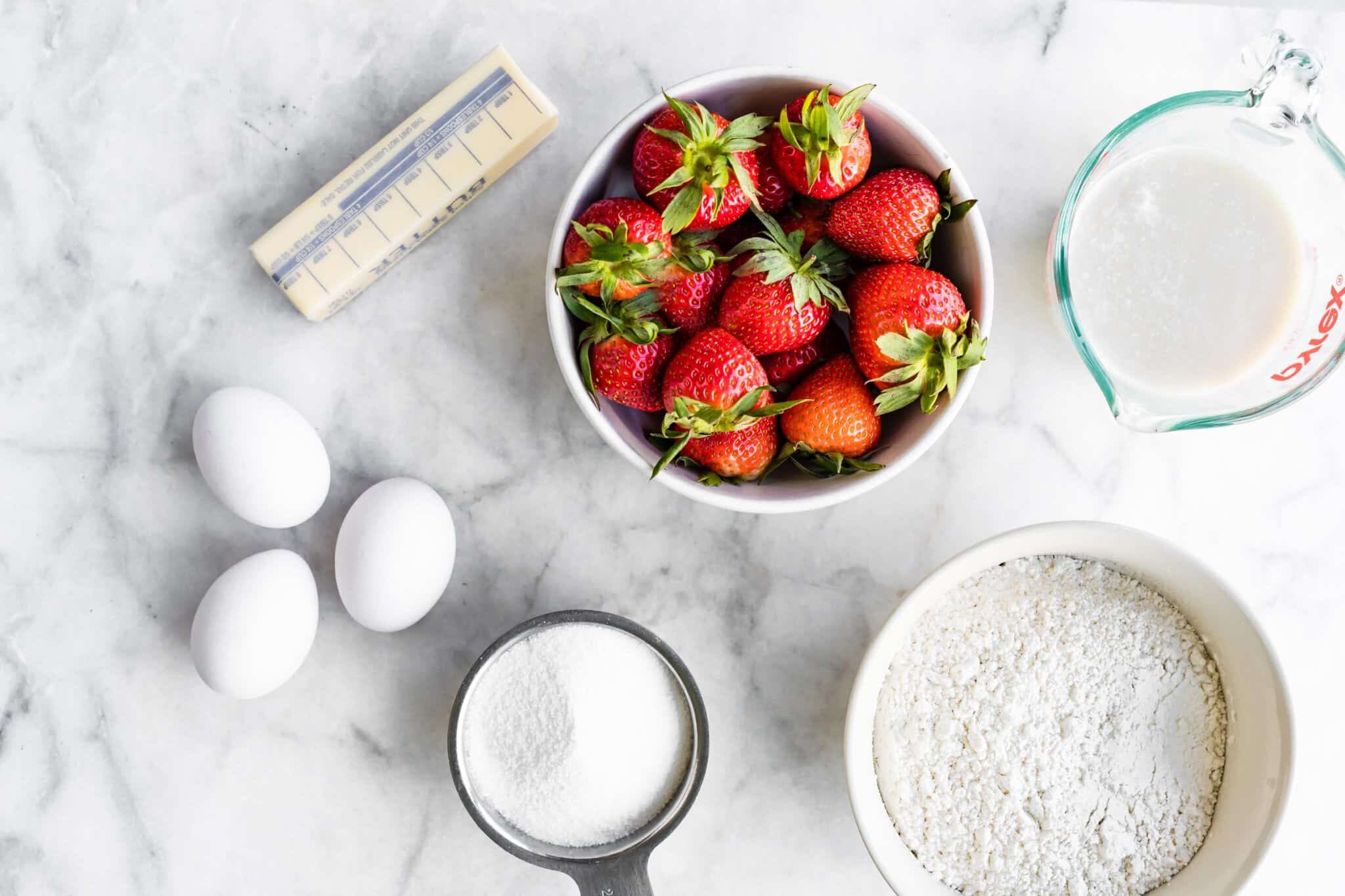 Fresh strawberries, gluten free flour, eggs and butter for a cake.
