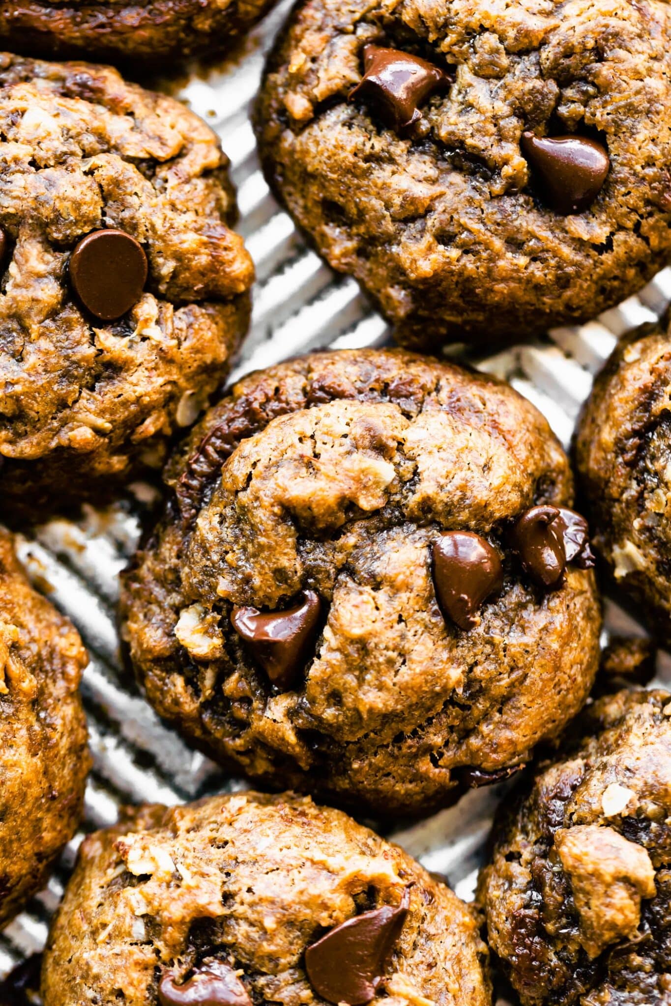 Overhead photo of breakfast cookies topped with chocolate chips on a sheet pan.