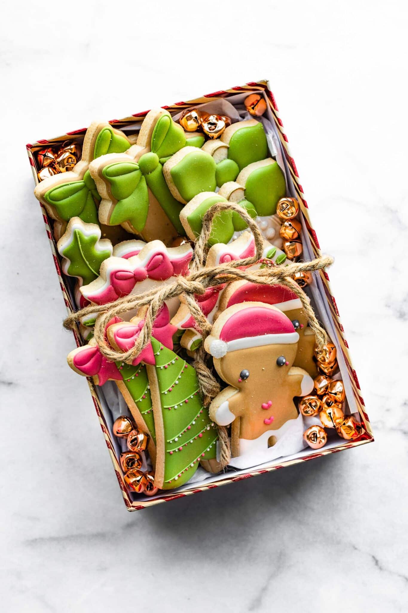 overhead photo of gluten free cut out cookies in a box with yarn tied around it.
