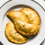 Overhead photo of four gluten free apple hand pies on a white plate.