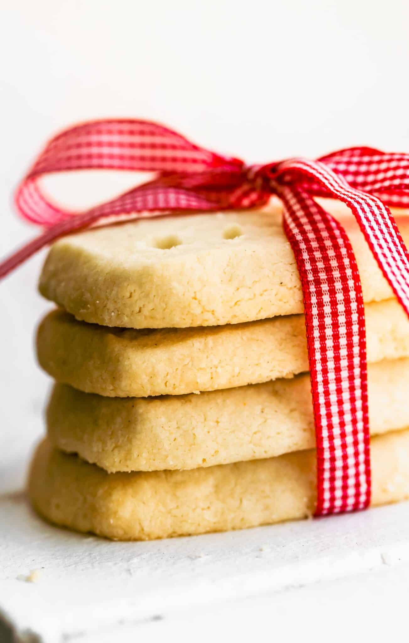 A stack of four rectangular gluten free shortbread cookies wrapped in a red ribbon.