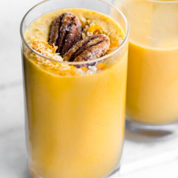 Glass of carrot cake smoothie with nuts and coconut on top