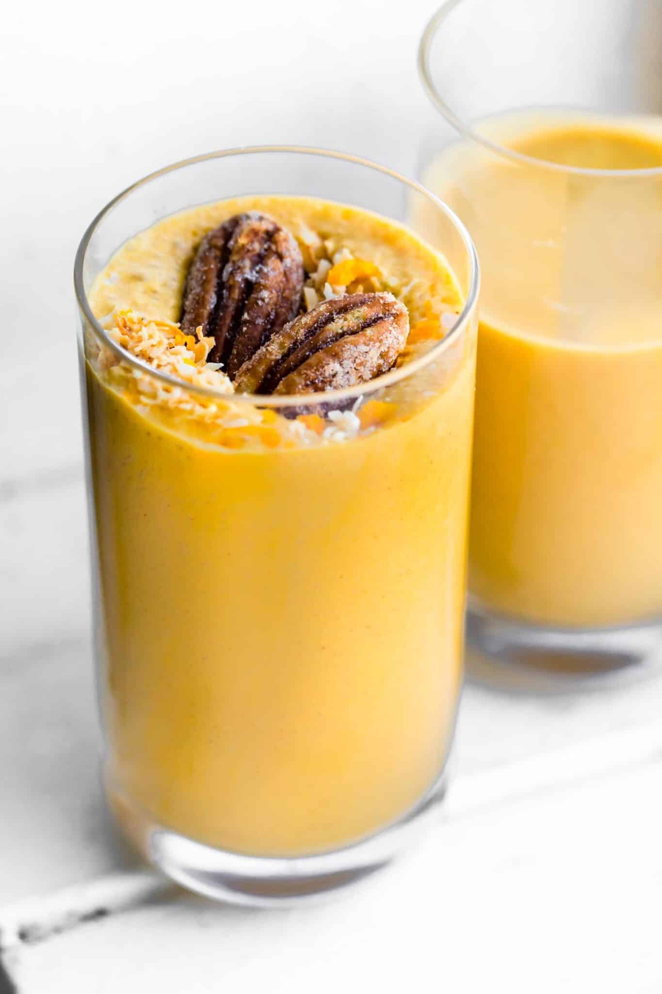Glass of carrot cake smoothie with nuts and coconut on top