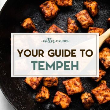 Cubes of marinated tempeh being sauteed in a cast iron skillet