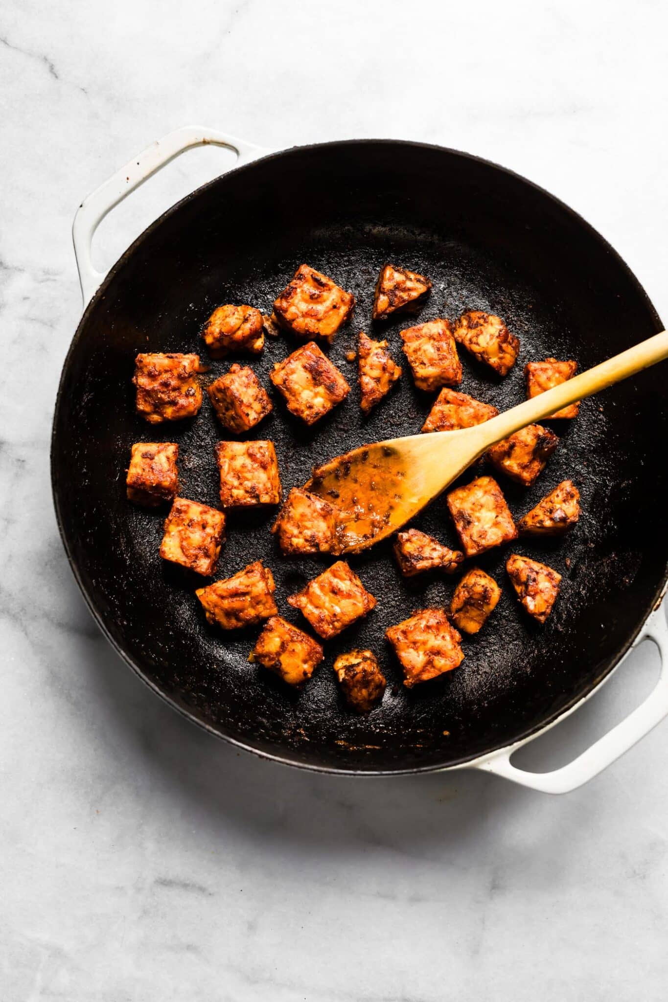 BBQ tempeh browned in a cast iron pan.