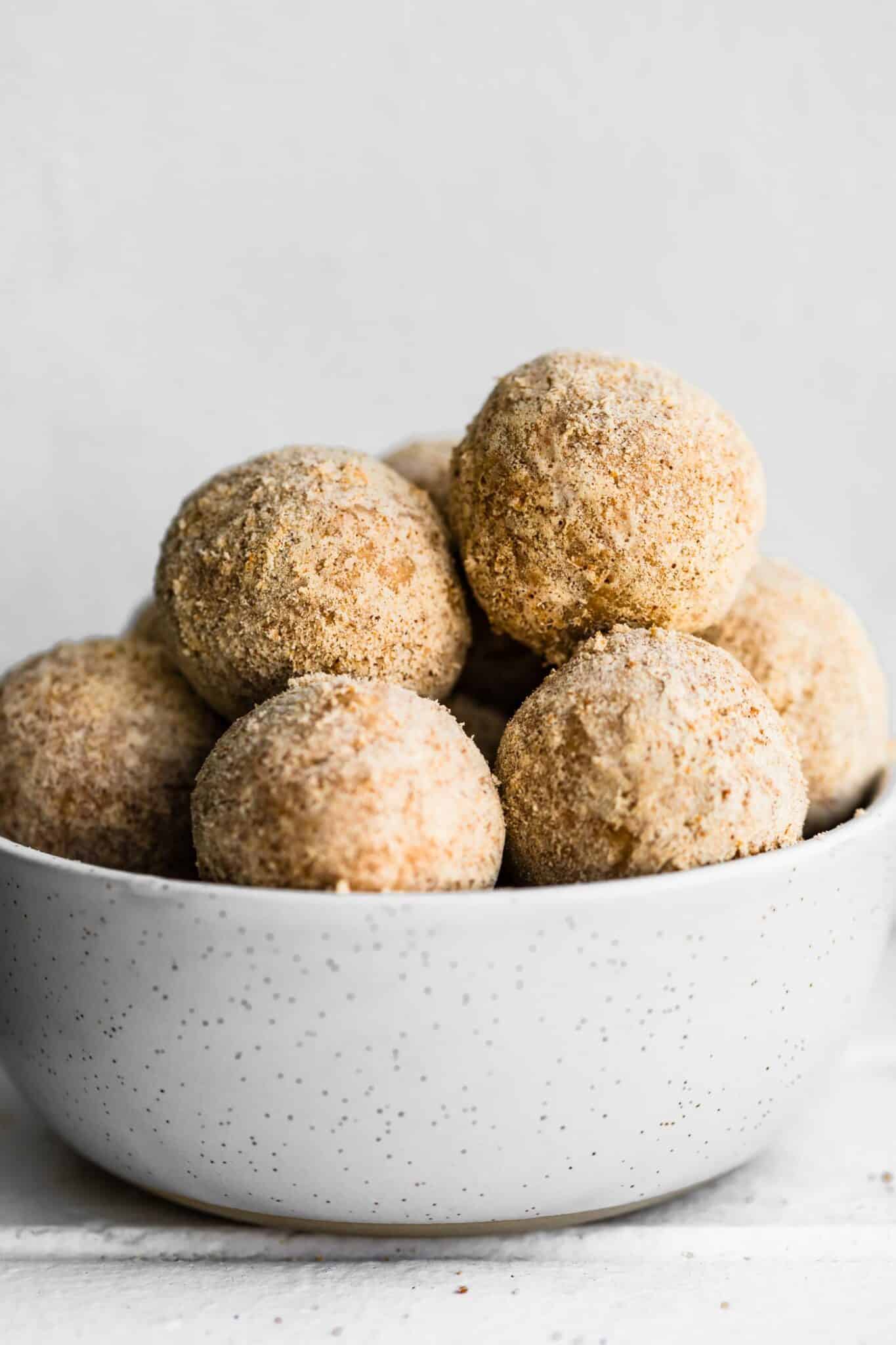 caramel snickerdoodle protein balls stacked in a white bowl