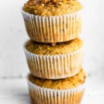 Three gluten free banana muffins stacked on top of each other.