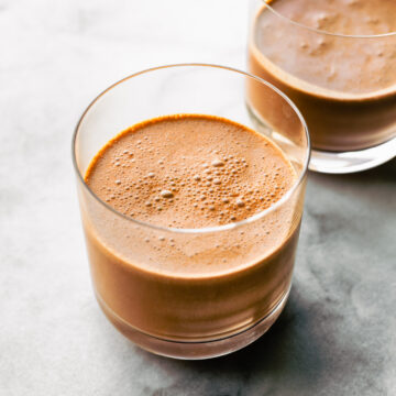 Two glasses filled with freshly blended chocolate coconut smoothie