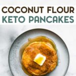 A stack of Coconut Flour Pancakes topped with a pat of butter and syrup on a plate with a text overlay for Pinterest.