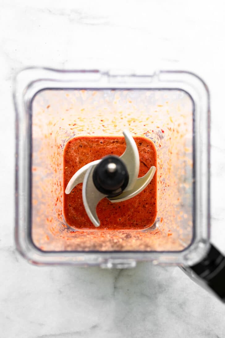Smooth red marinade blended in a blender viewed from above.