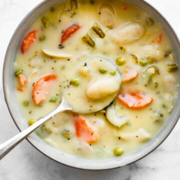 Overhead photo of a spoon in a bowl of gluten free chicken and gnocchi soup.